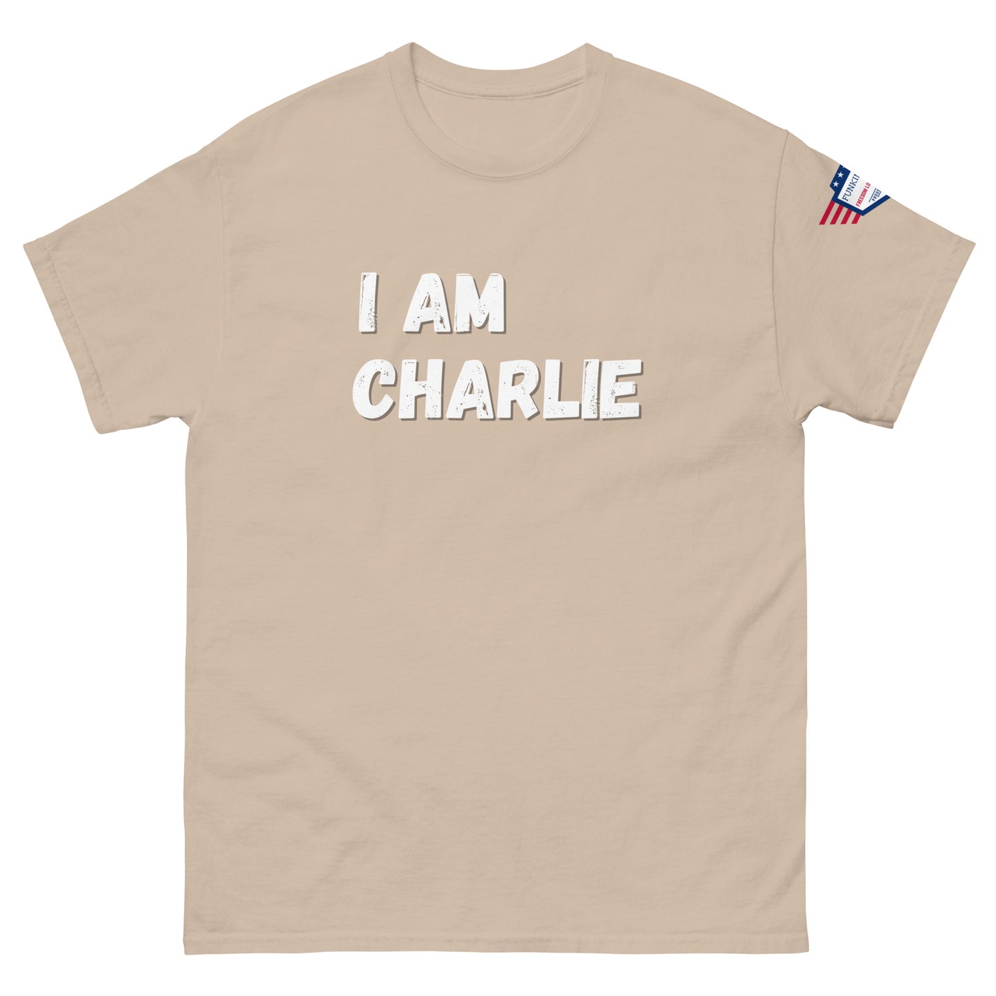 Beige unisex tee front with white "I AM CHARLIE" text, US flag sleeve detail