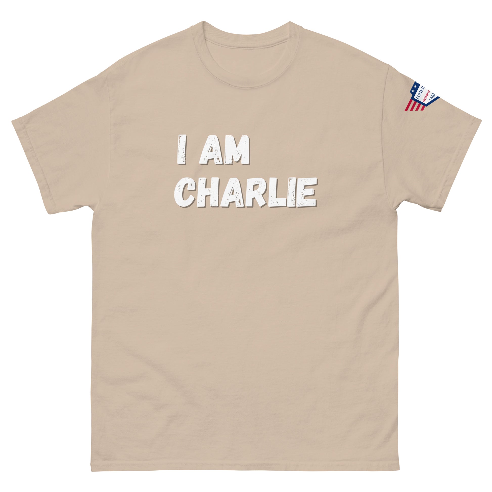 Beige unisex tee front with white "I AM CHARLIE" text, US flag sleeve detail