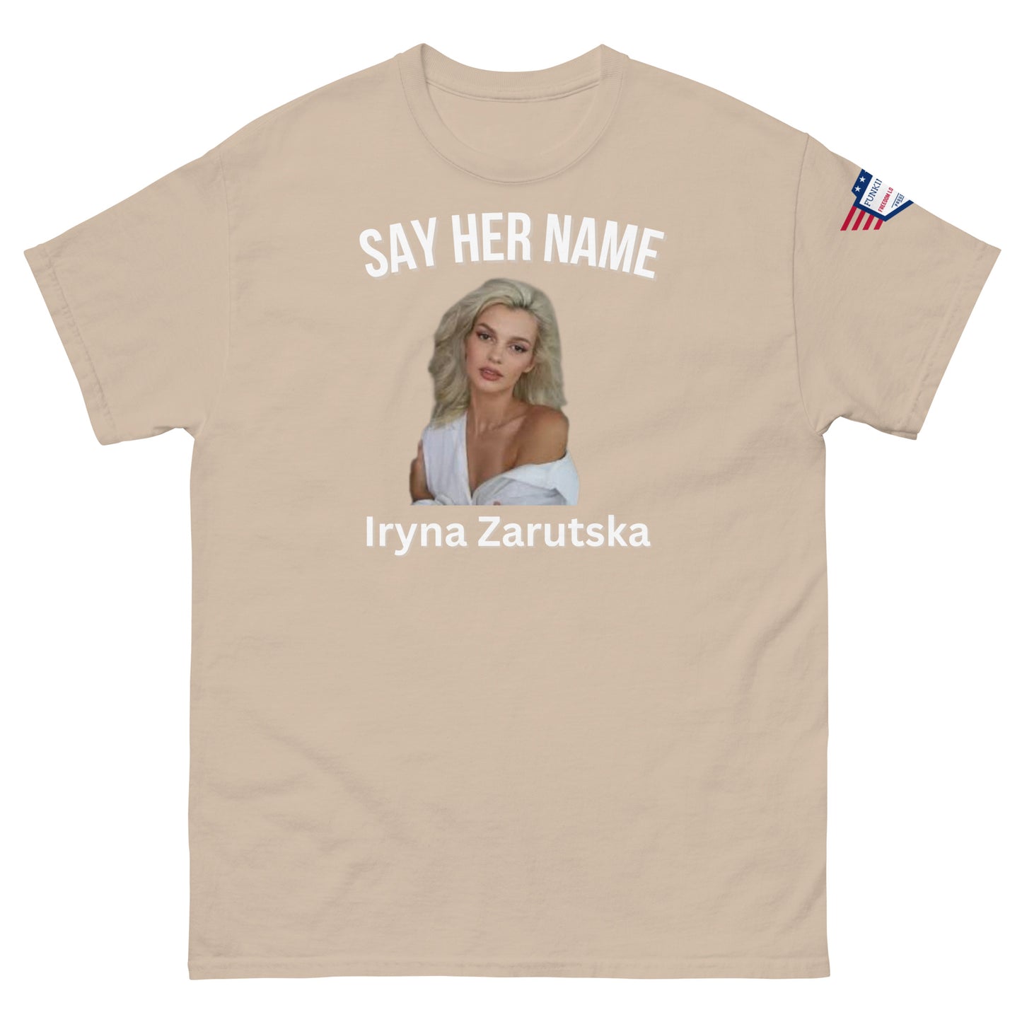 Front view of light ash unisex tee: "SAY HER NAME" over Iryna Zarzutska portrait, name in white, subtle flag sleeve patch