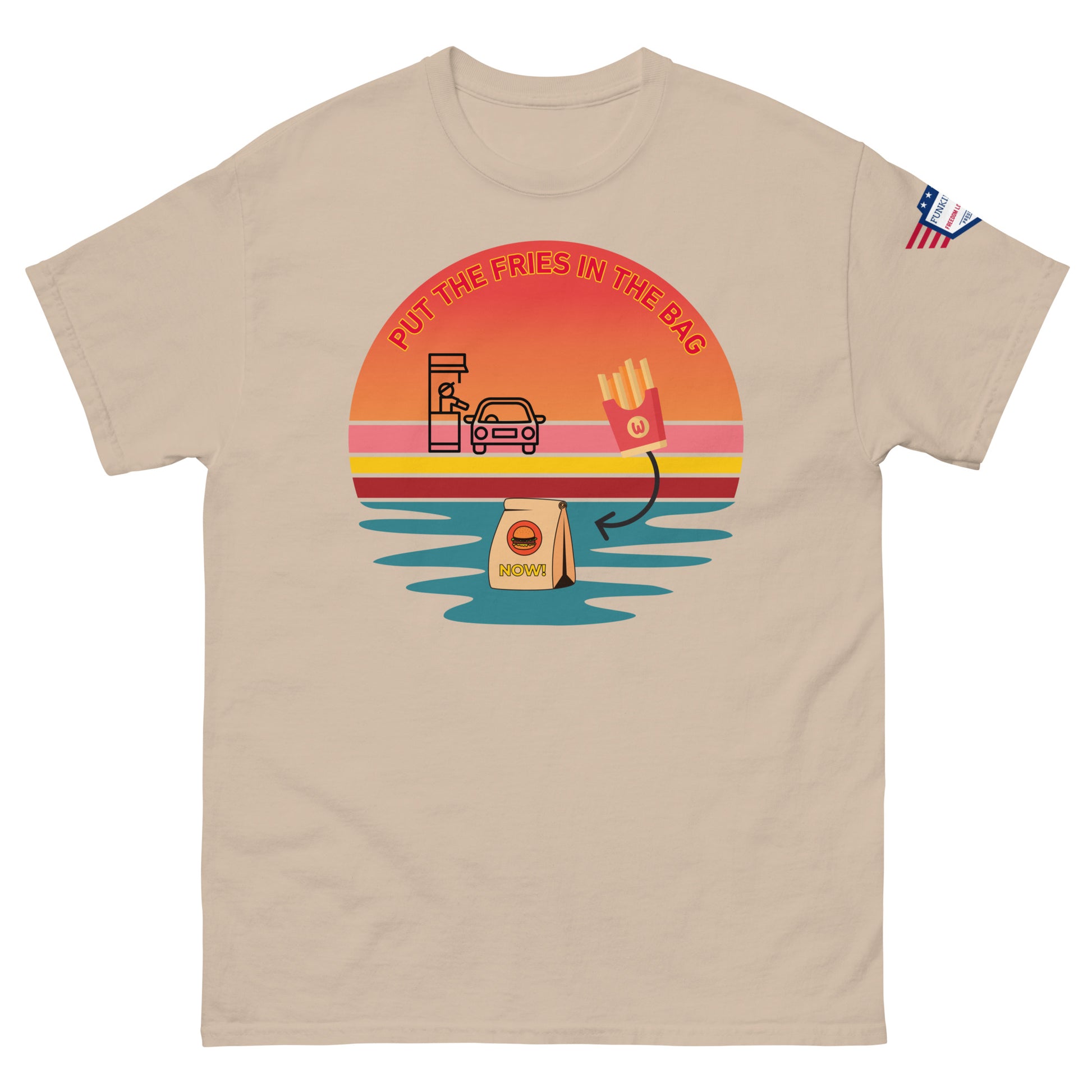 Front view of beige unisex T-shirt with "PUT THE FRIES IN THE BAG" drive-thru sunset print and subtle US flag sleeve patch