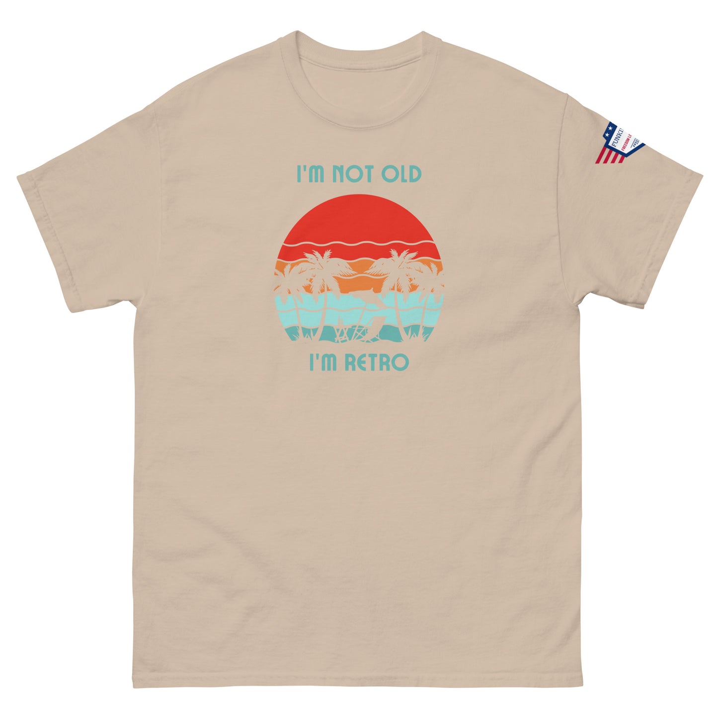 Front view of tan "I'm Not Old I'm Retro" tee with sunset hammock design and USA flag patch