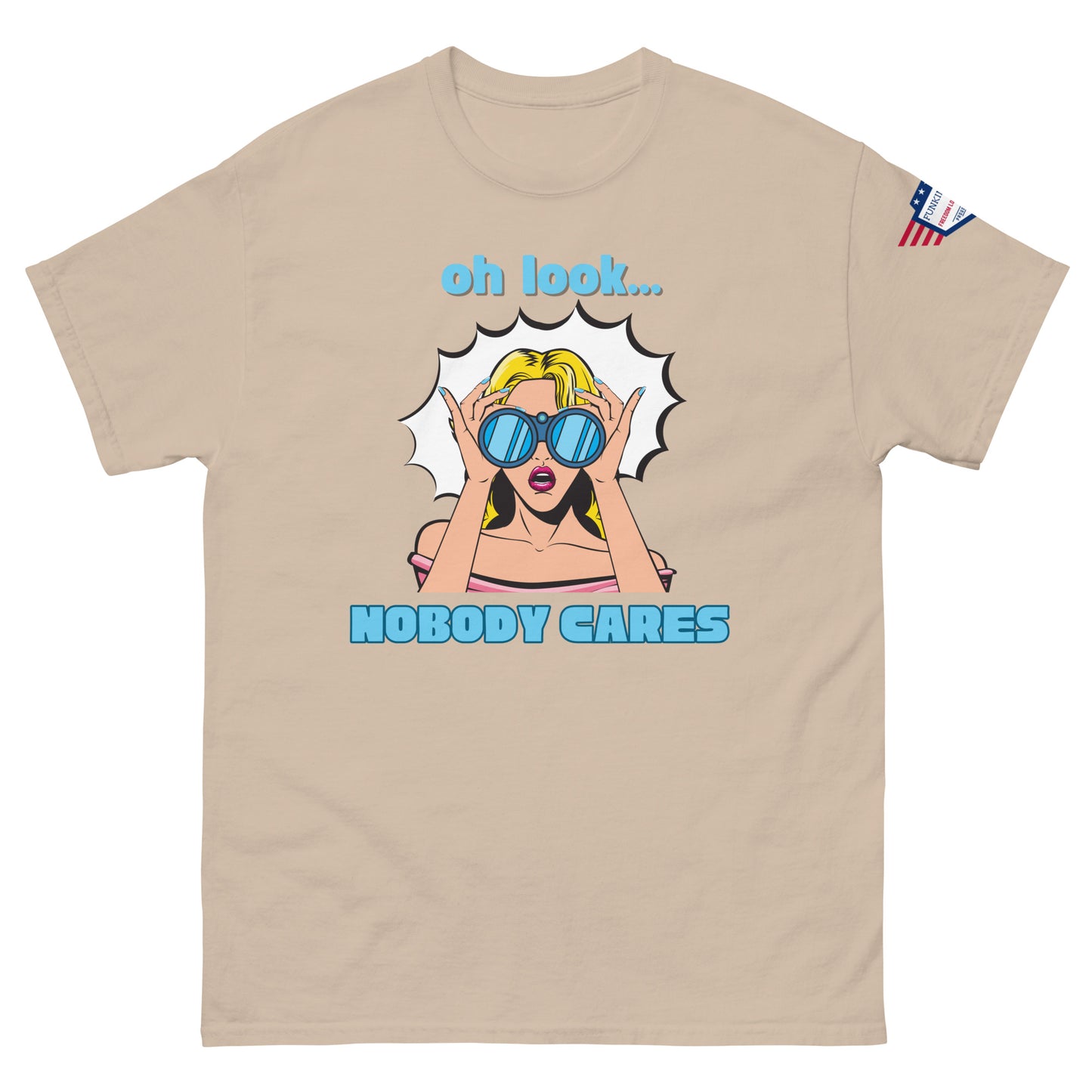 Front view of sand beige unisex t-shirt showing "oh look... NOBODY CARES" pop-art print, USA sleeve patch