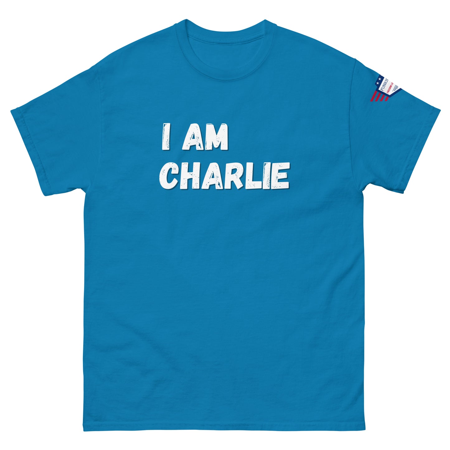 Front view of sky blue unisex tee with bold white "I AM CHARLIE" graphic and small USA flag sleeve patch