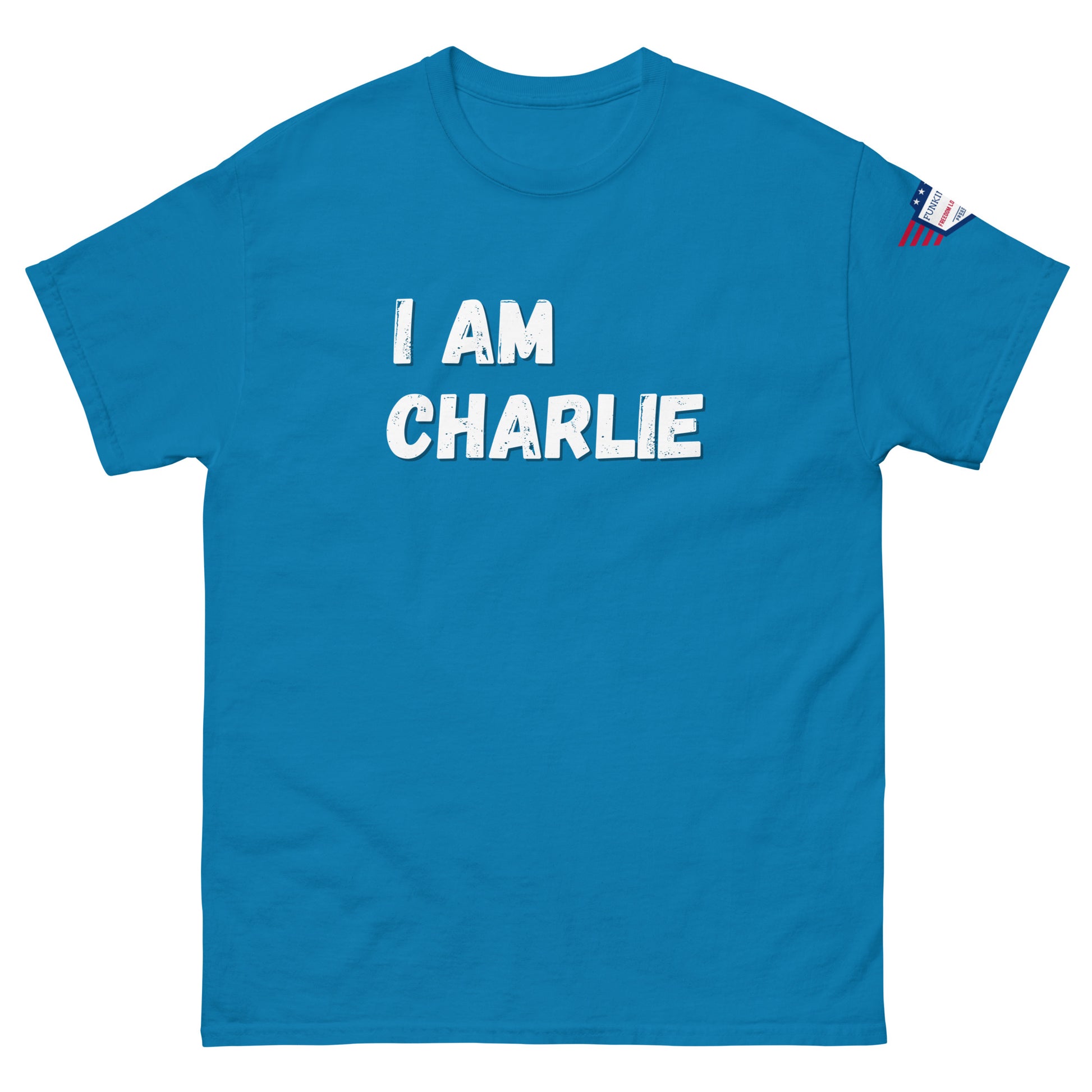 Front view of sky blue unisex tee with bold white "I AM CHARLIE" graphic and small USA flag sleeve patch