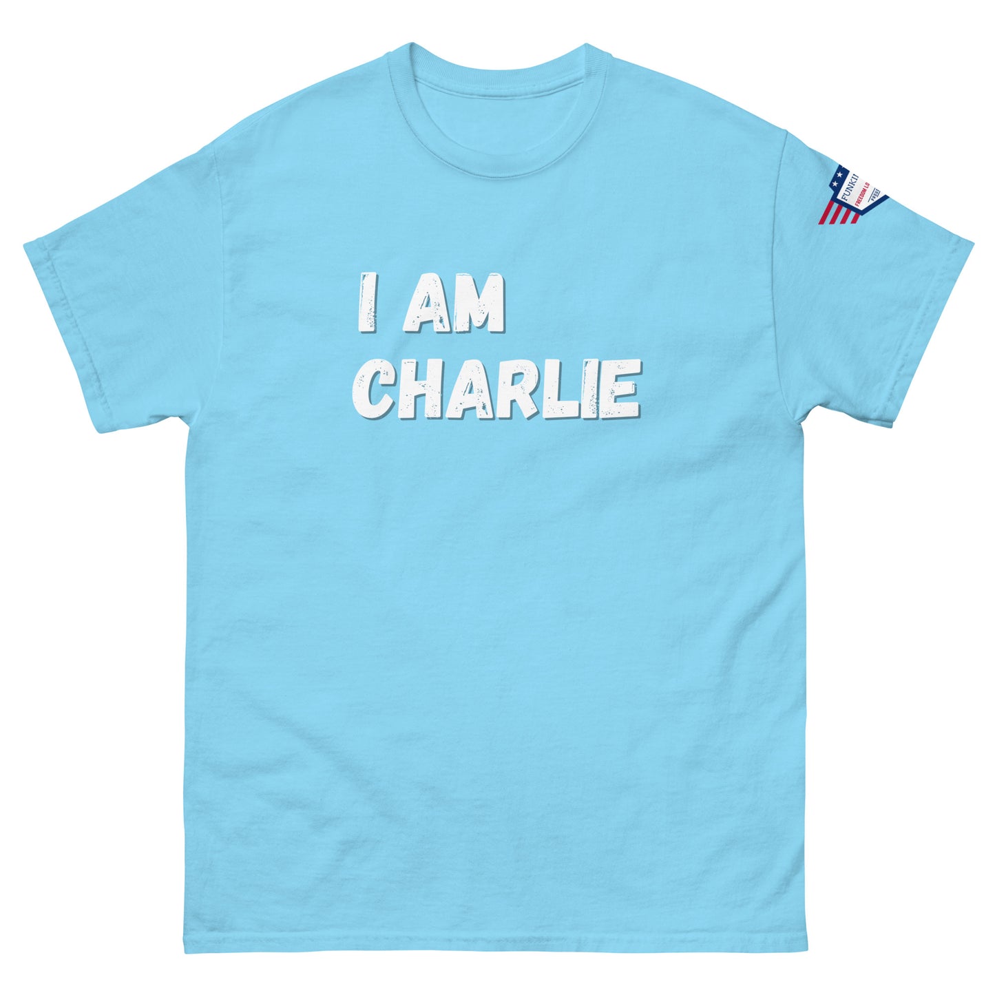 Front view of sky blue unisex tee with bold white "I AM CHARLIE" graphic and small USA flag sleeve patch