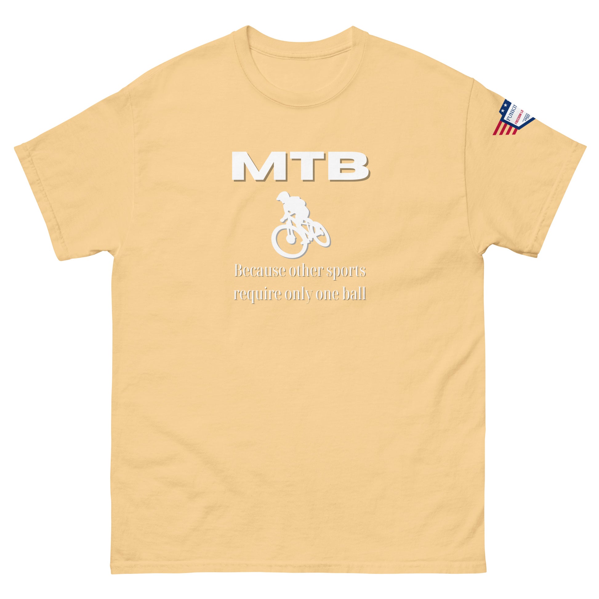 Front view of tan unisex tee with white "MTB" bold print, rider icon, "Because other sports require only one ball", US flag sleeve patch