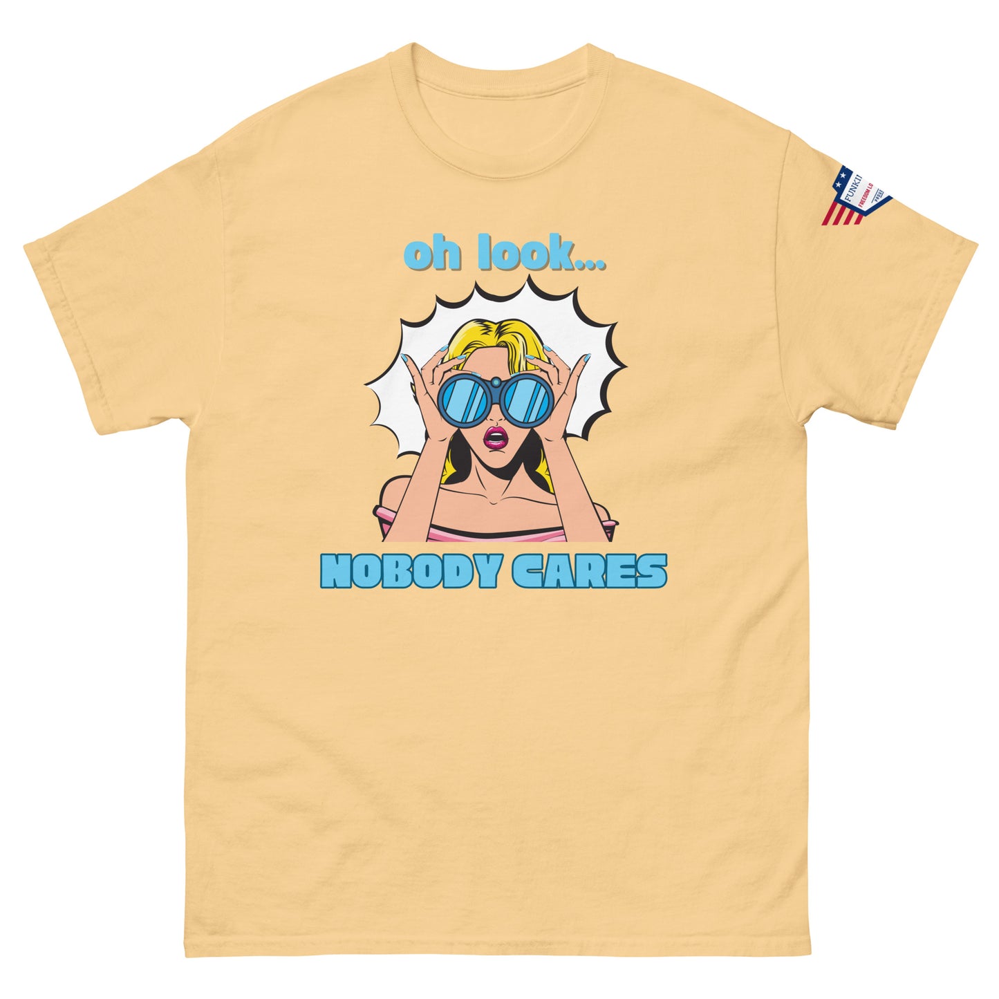 Front view of sand beige unisex t-shirt featuring "oh look... NOBODY CARES" cyan pop art print and USA sleeve patch