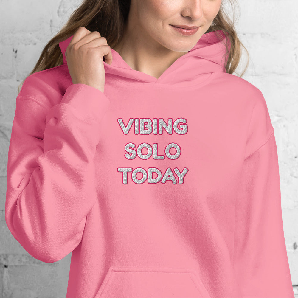 Front close-up of smiling model in hot pink hoodie, bold "VIBING SOLO TODAY" embroidery