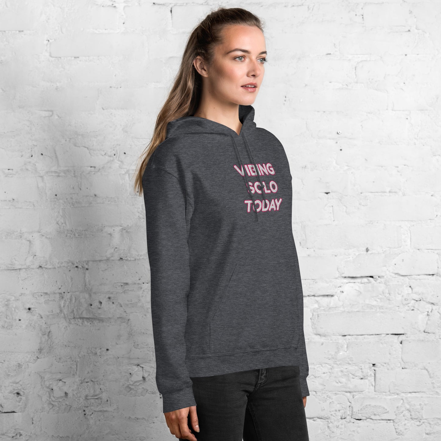 Right 3/4 view of heather gray hoodie on model with pink "VIBING SOLO TODAY" embroidery visible