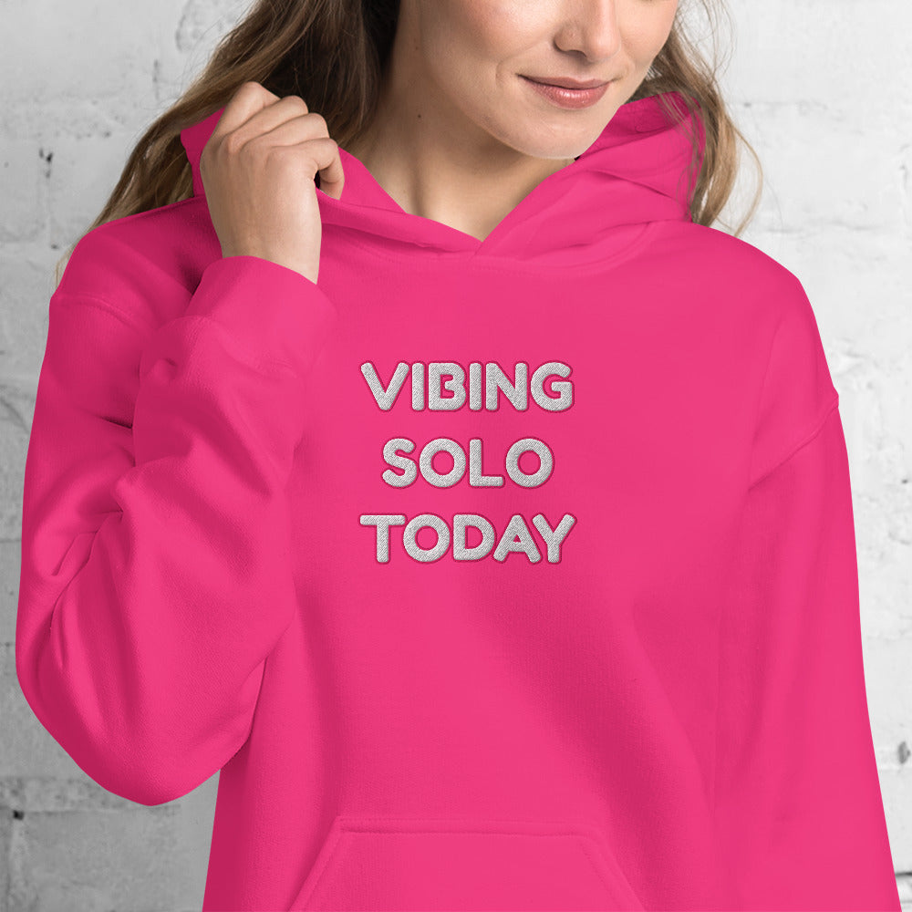 Model smiling in front view of hot pink hoodie with stacked white "VIBING SOLO TODAY" embroidery