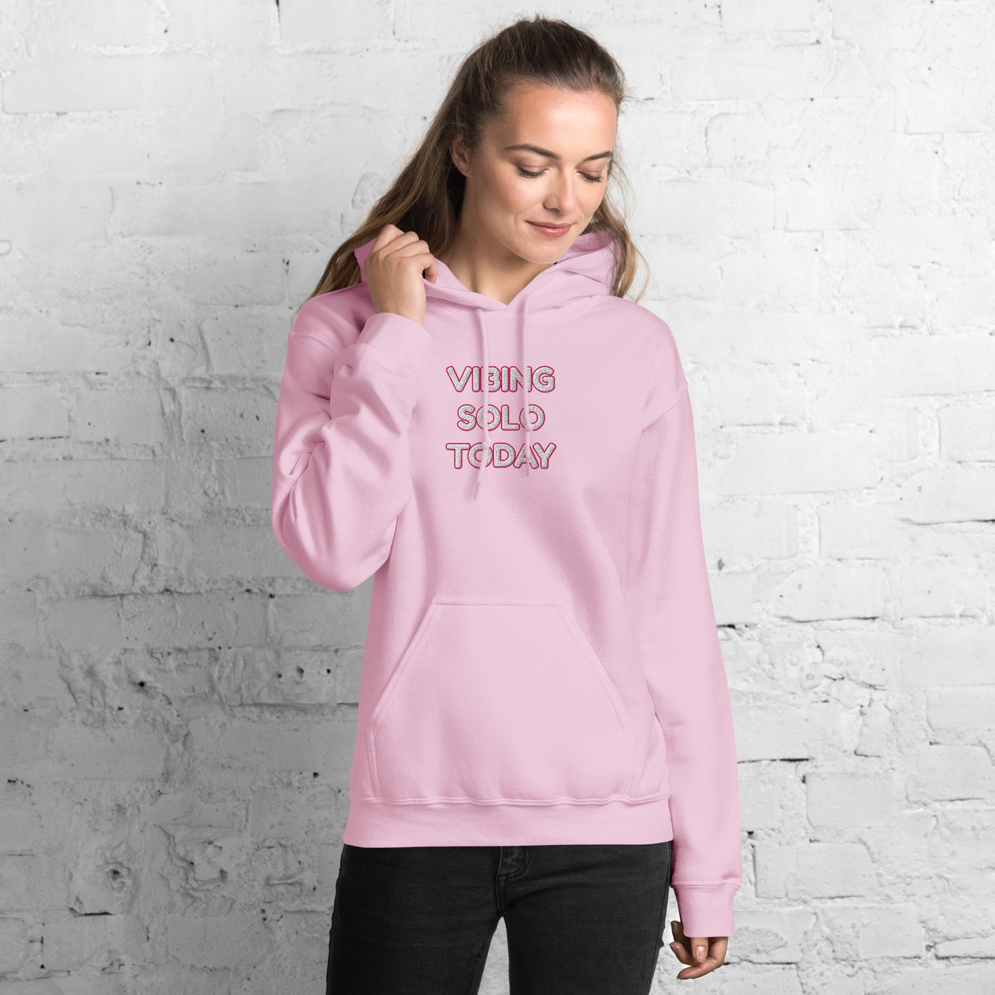 Right side angle of smiling model in hot pink "VIBING SOLO TODAY" embroidered hoodie
