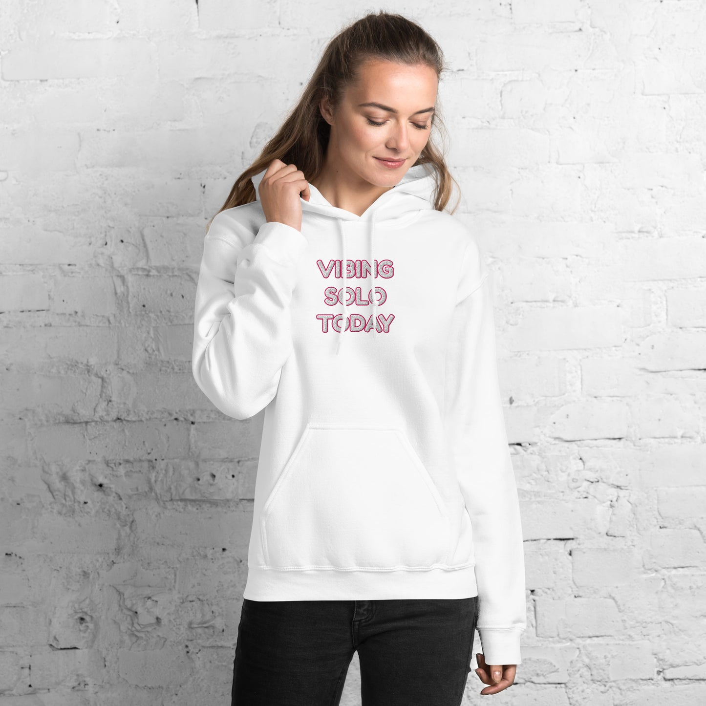 Three-quarter front view of model in white hoodie showing pink "VIBING SOLO TODAY" embroidery