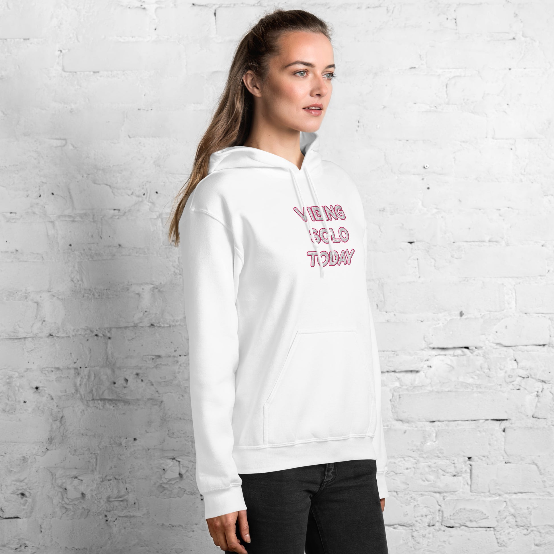 Right side profile of model in white "Vibing Solo Today" pink-embroidered hoodie, casual pose