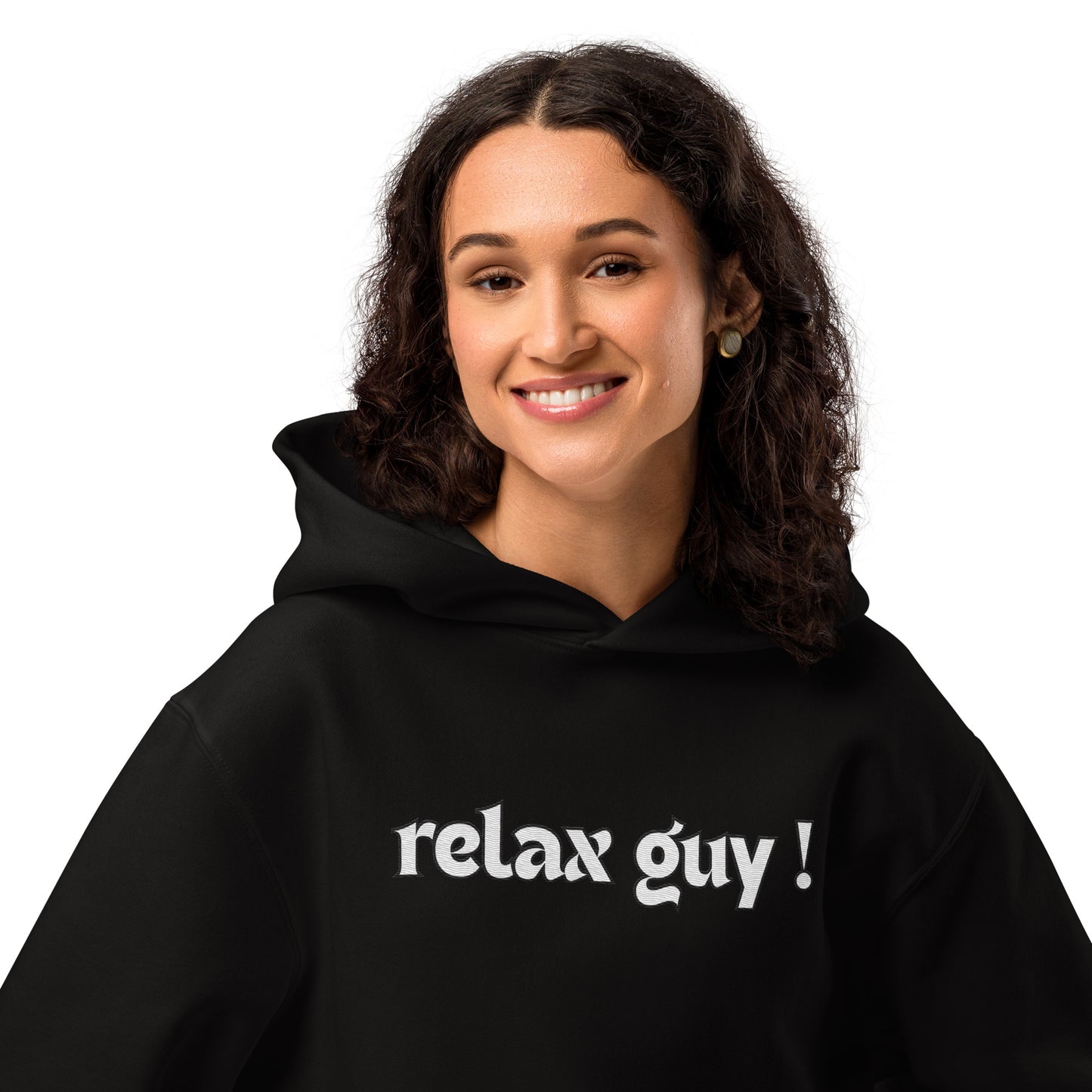 Smiling curly-haired woman rocking black oversized "relax guy !" hoodie, front view