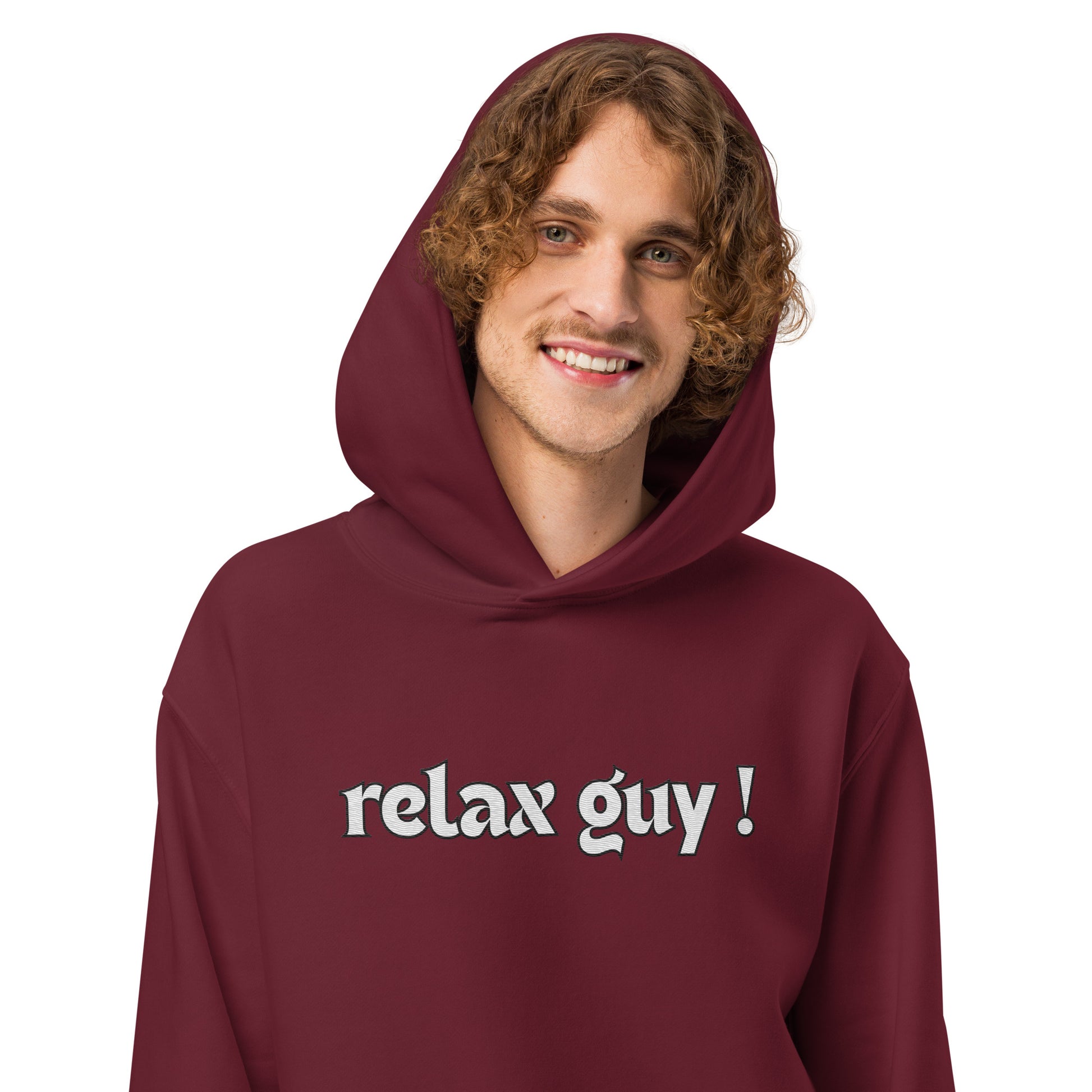 Curly-haired guy in maroon oversized "relax guy !" hoodie, smiling front pose