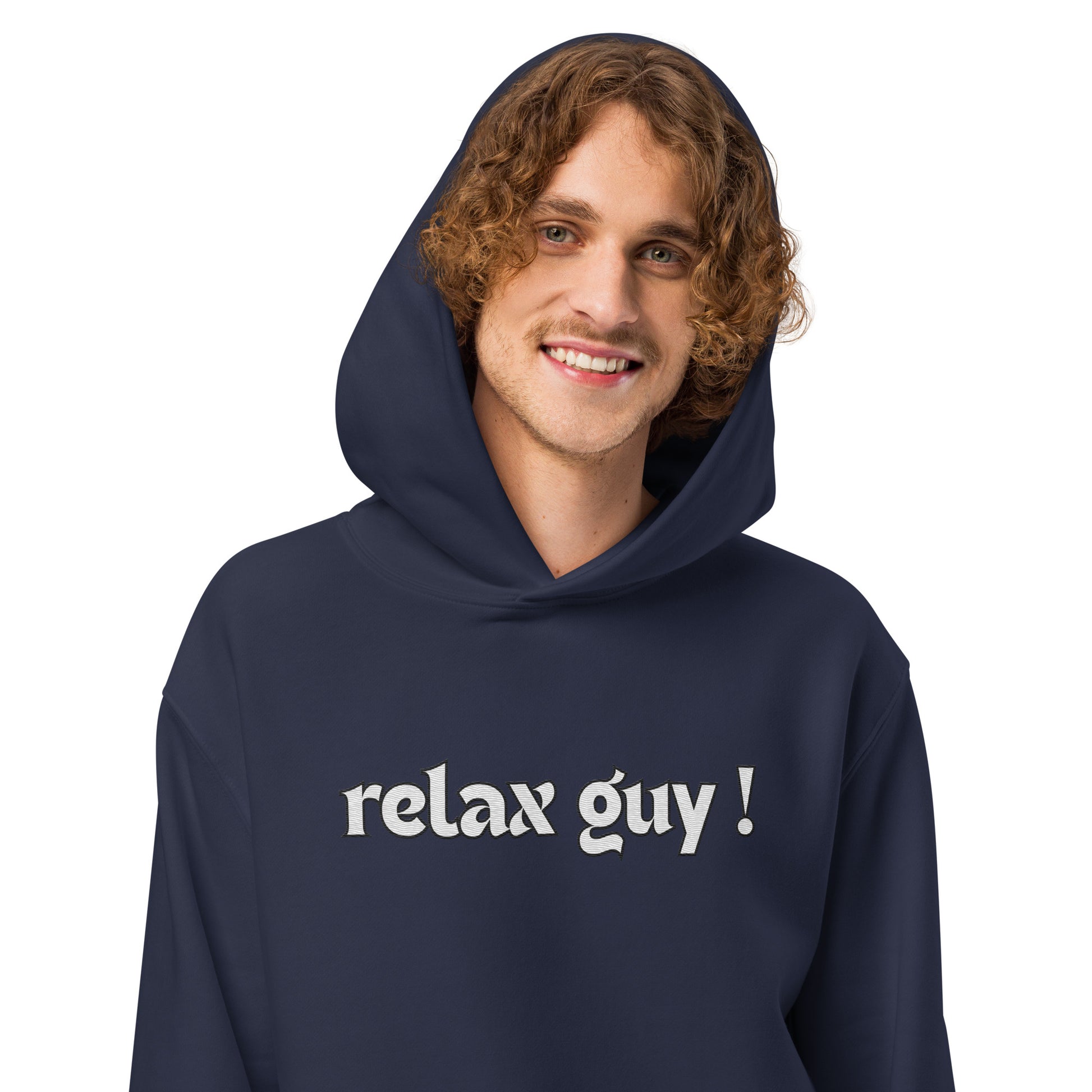 Curly-haired man grinning in navy "relax guy !" oversized hoodie, front view