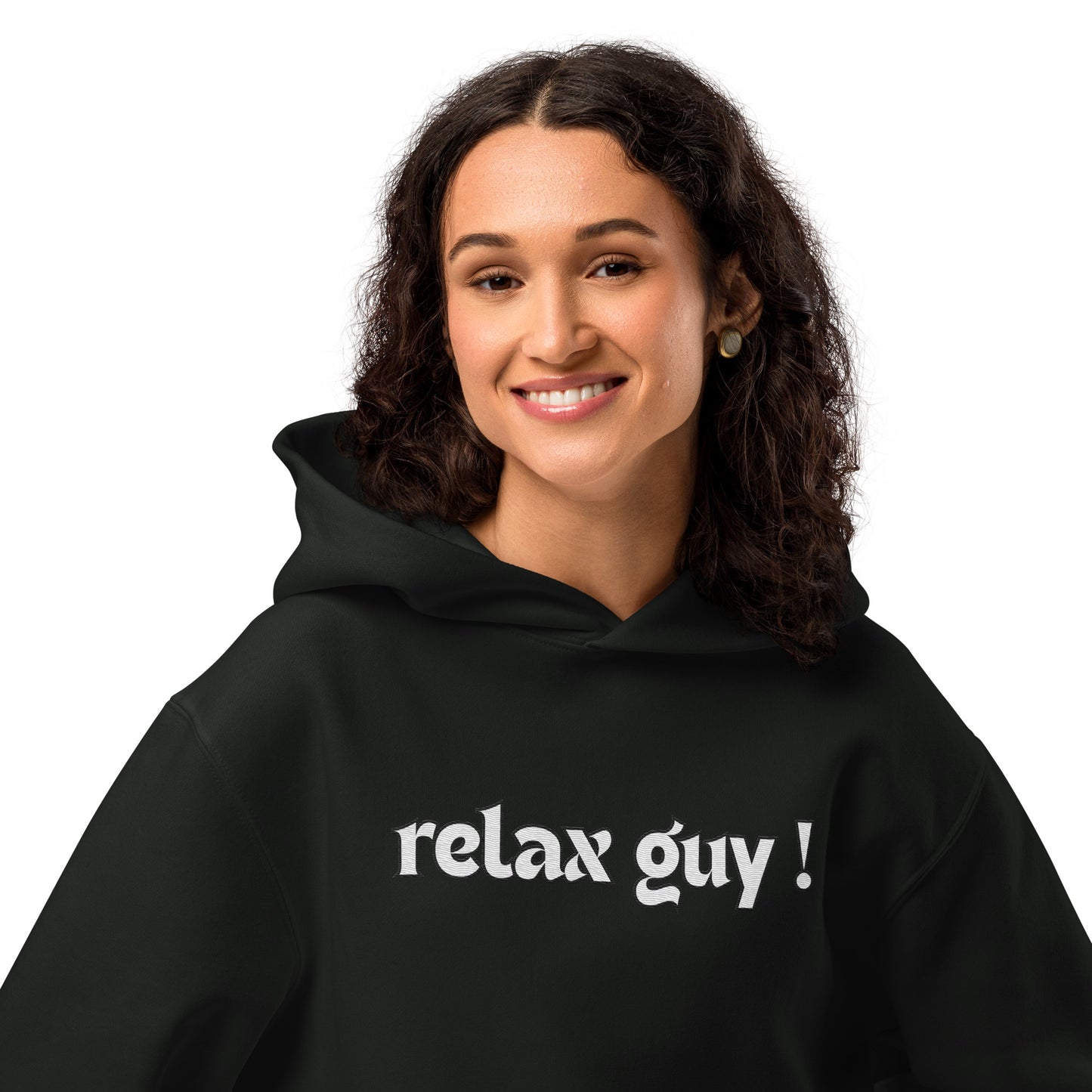 Smiling curly-haired woman in black oversized "relax guy !" hoodie, front view