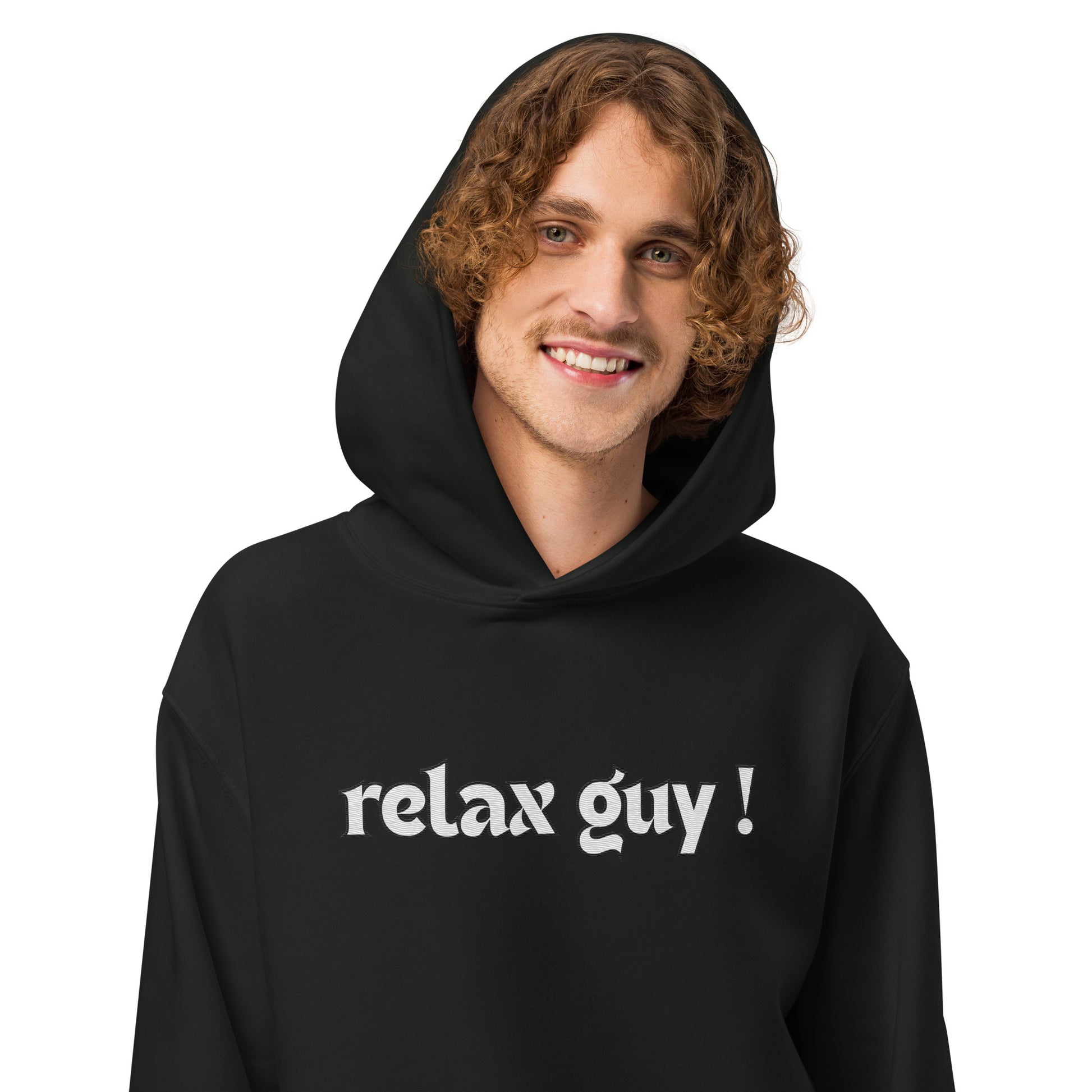 Curly-haired dude smiling in black "relax guy !" oversized hoodie, front pose