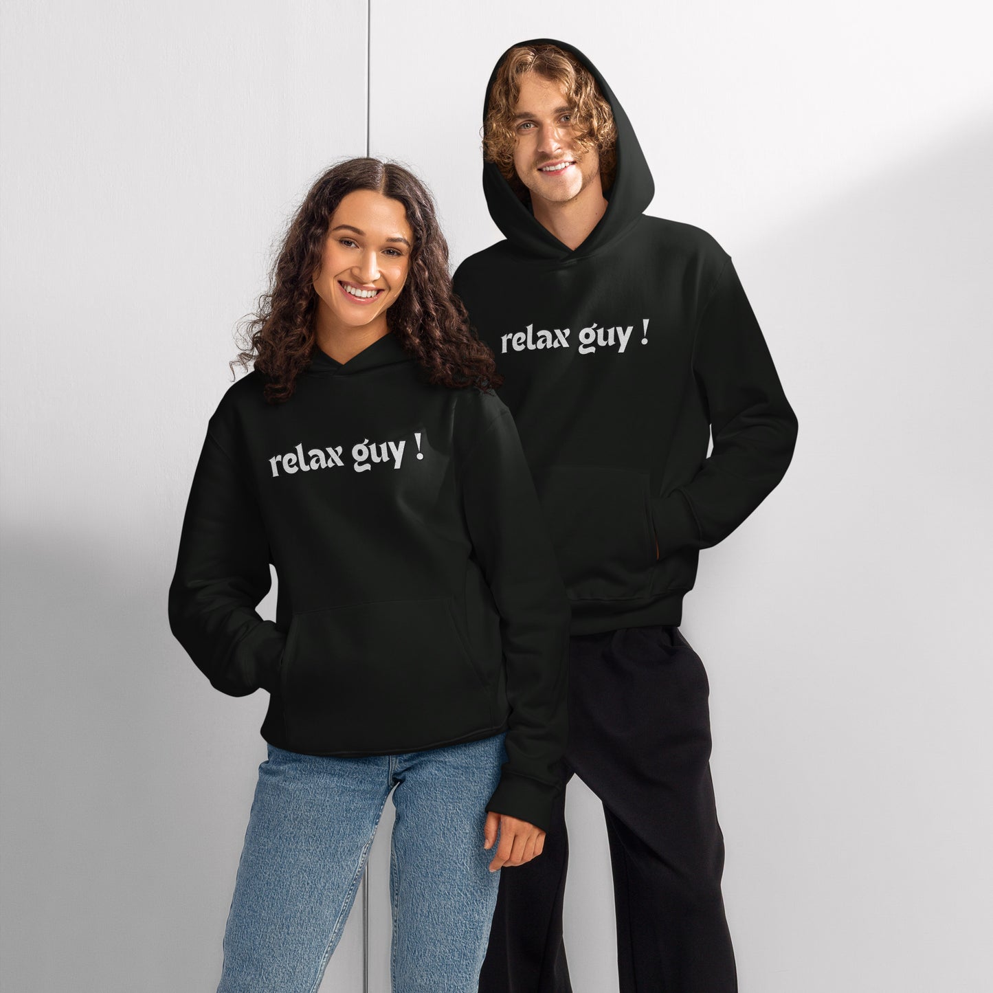 Happy couple posing in black oversized "relax guy !" hoodies, front view