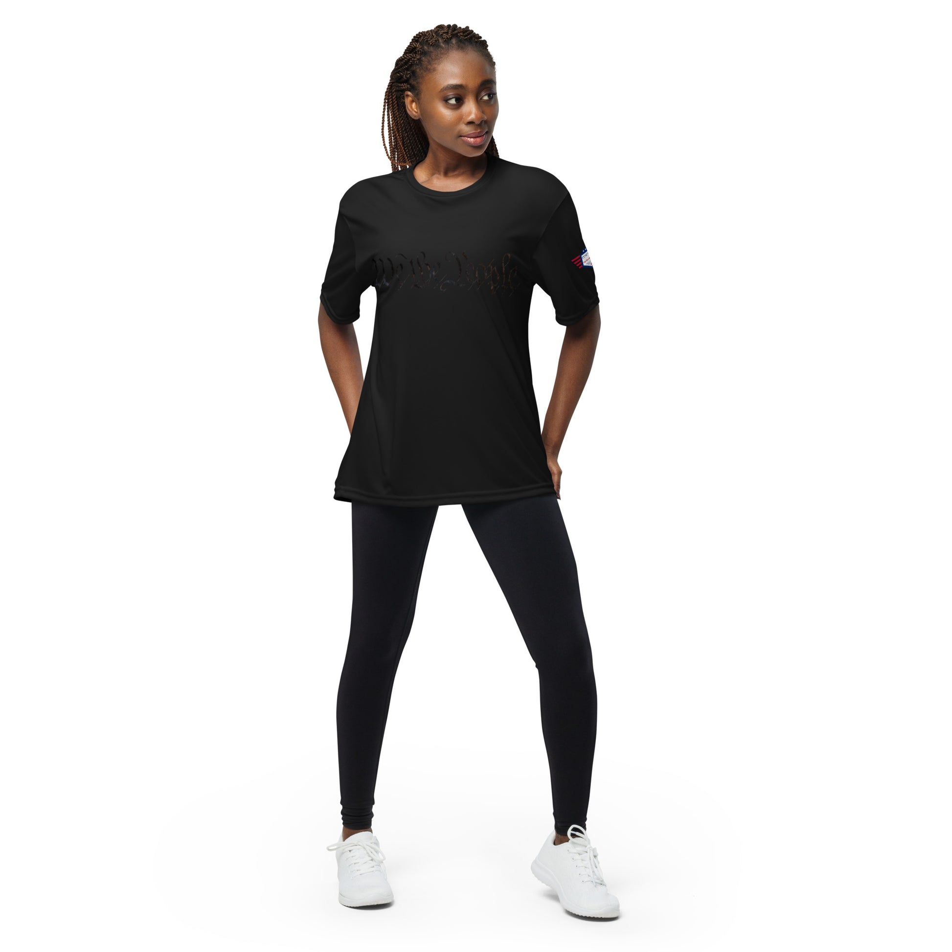 Woman modeling black "We The People" performance tee front, flag patch, hands on hips in leggings