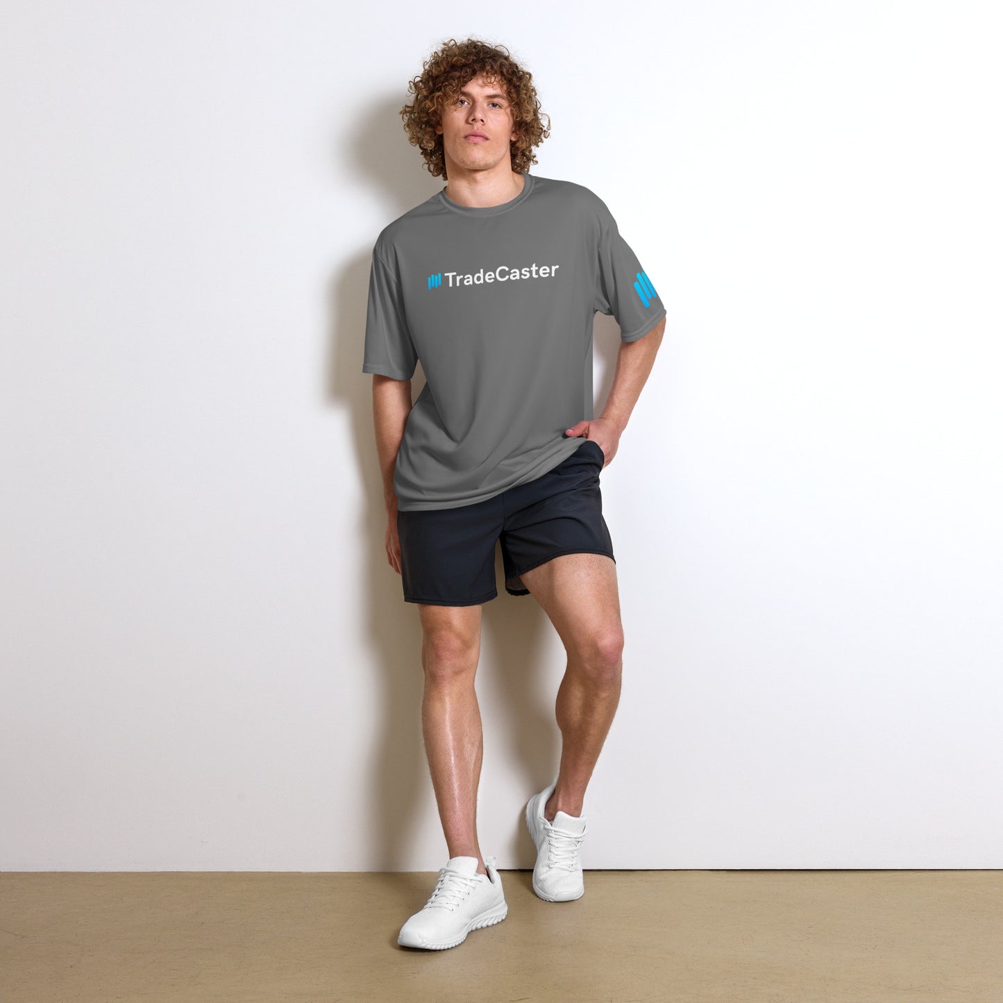 Guy models graphite TradeCaster tee front-on, cyan accents ready for gains