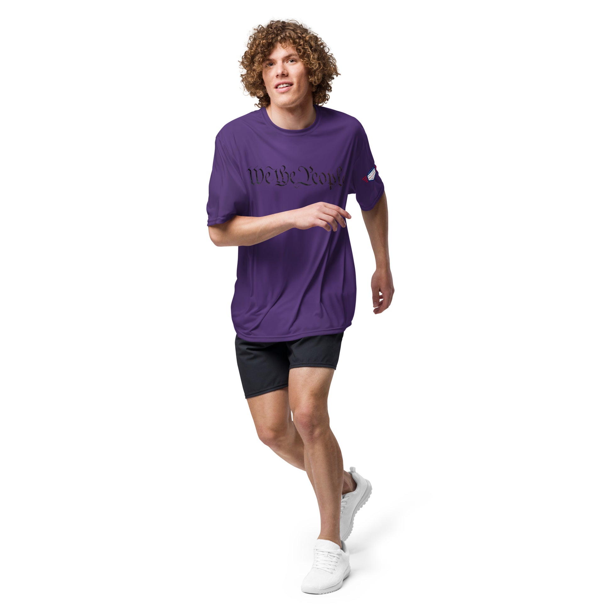 Guy running in purple "We The People" cursive tee, flag on sleeve, black shorts and sneaks