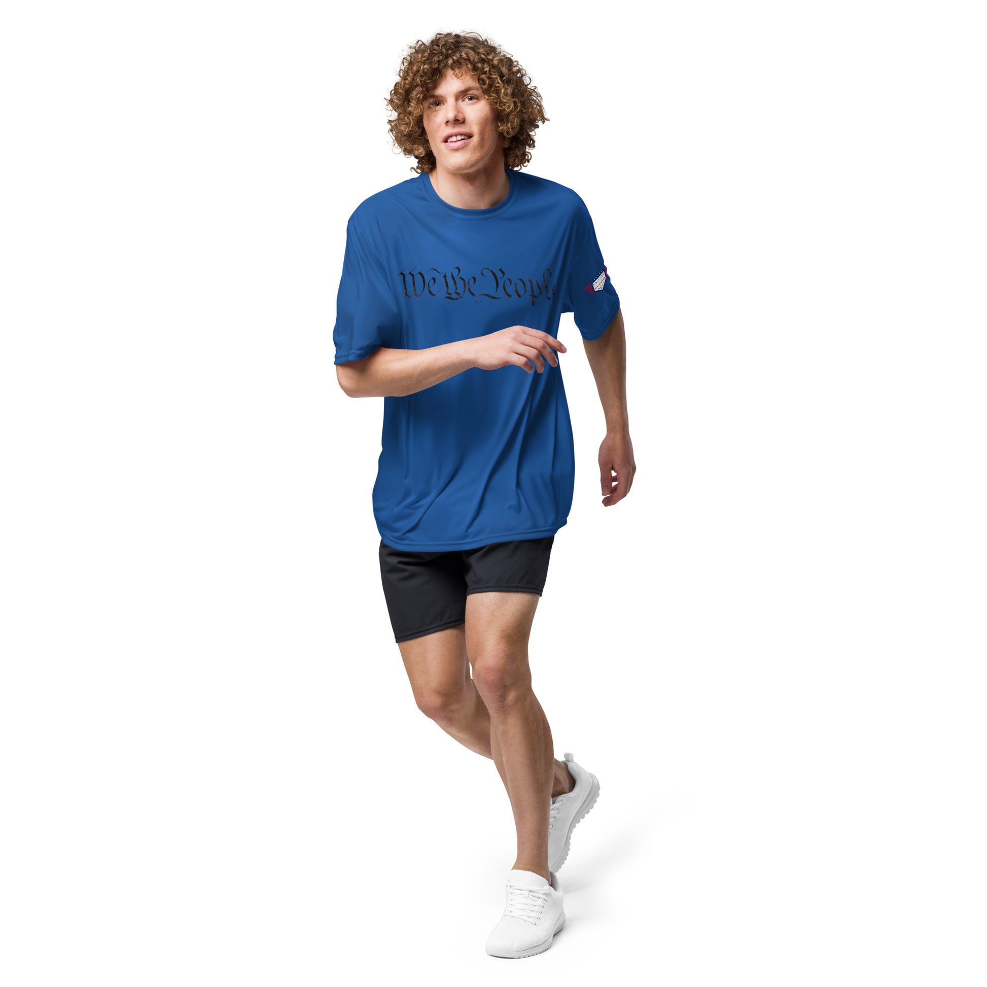 Curly-haired guy running in royal blue "We The People" performance tee, patriotic gym vibes