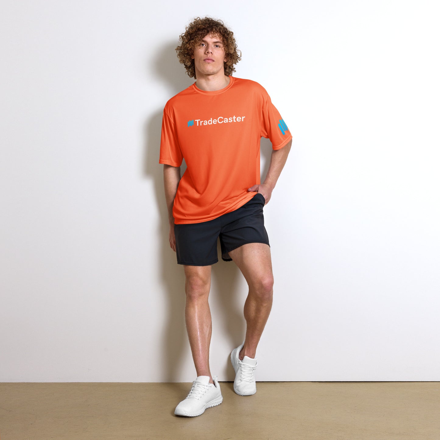 Curly-haired model fronts orange TradeCaster crew neck, cyan #TradeCaster print stealing the show
