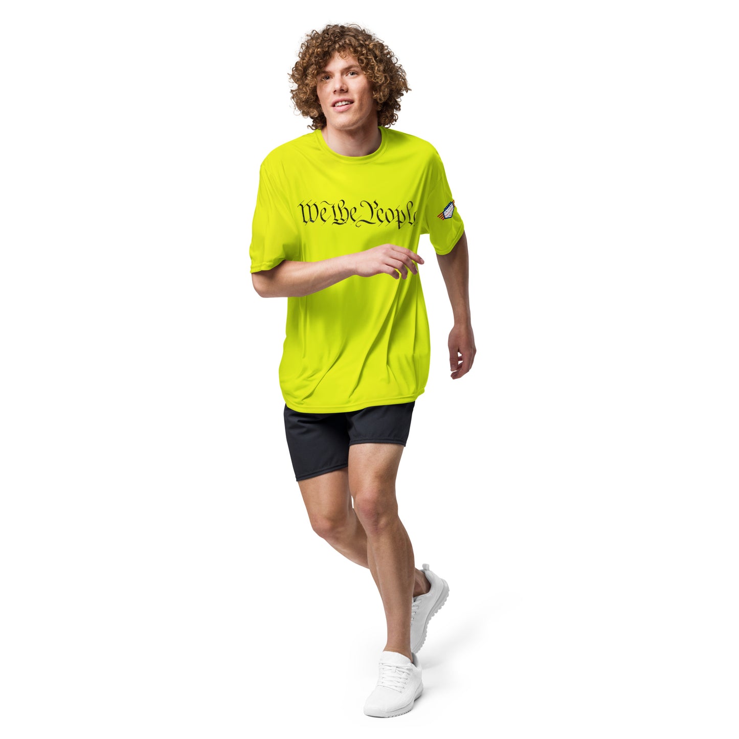 Curly-haired guy running in lime green tee: "We The People" front print, flag patch, mid-stride energy