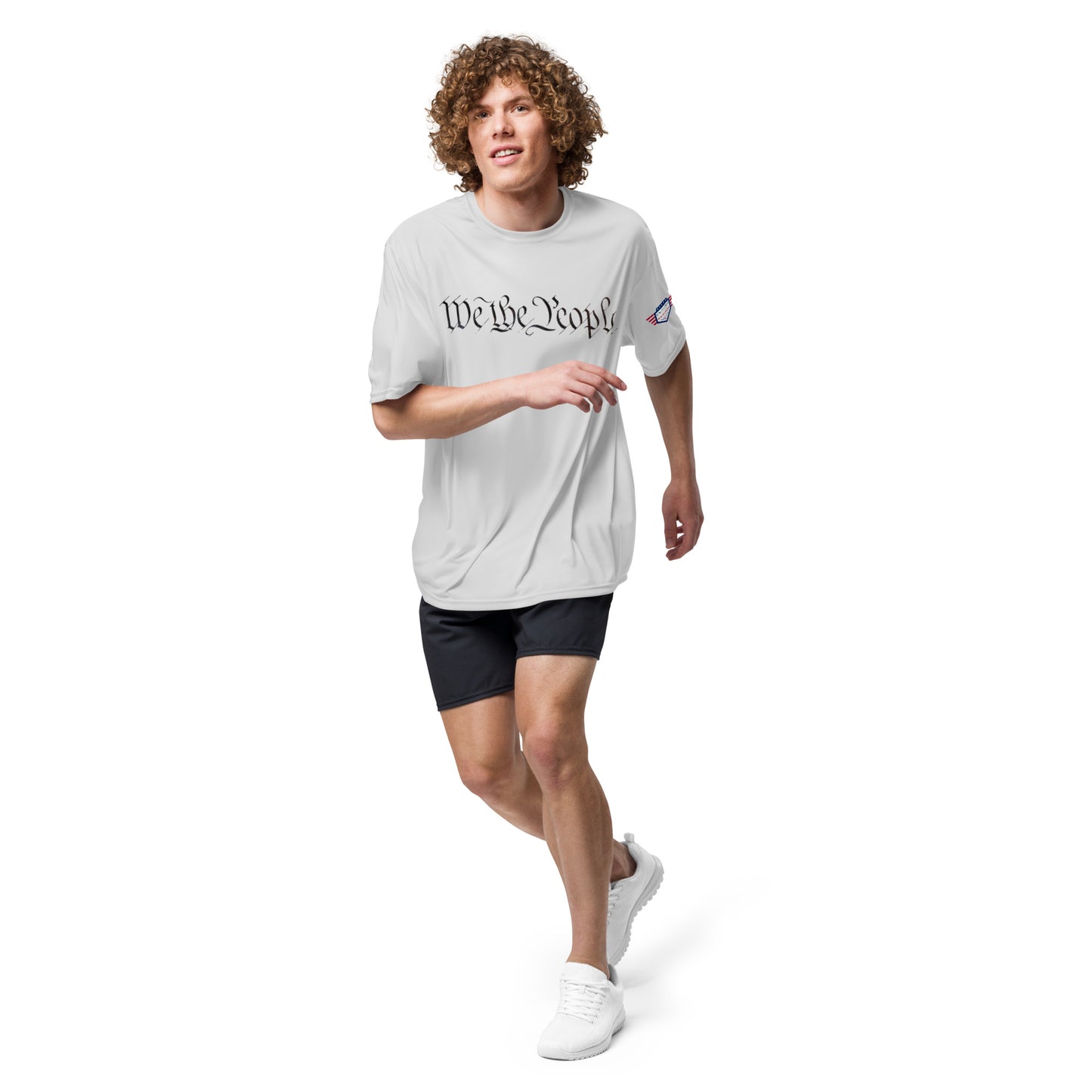 Curly-haired dude jogging in heather gray tee with "We The People" front and patriotic sleeve patch