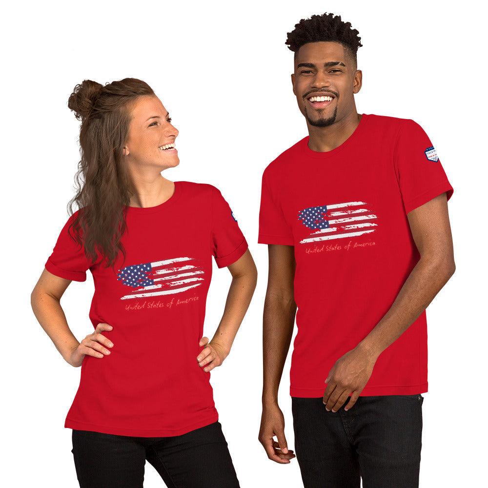 Smiling pair in red unisex USA shirts featuring splattered flag design, "United States of America" below, sleeve emblem