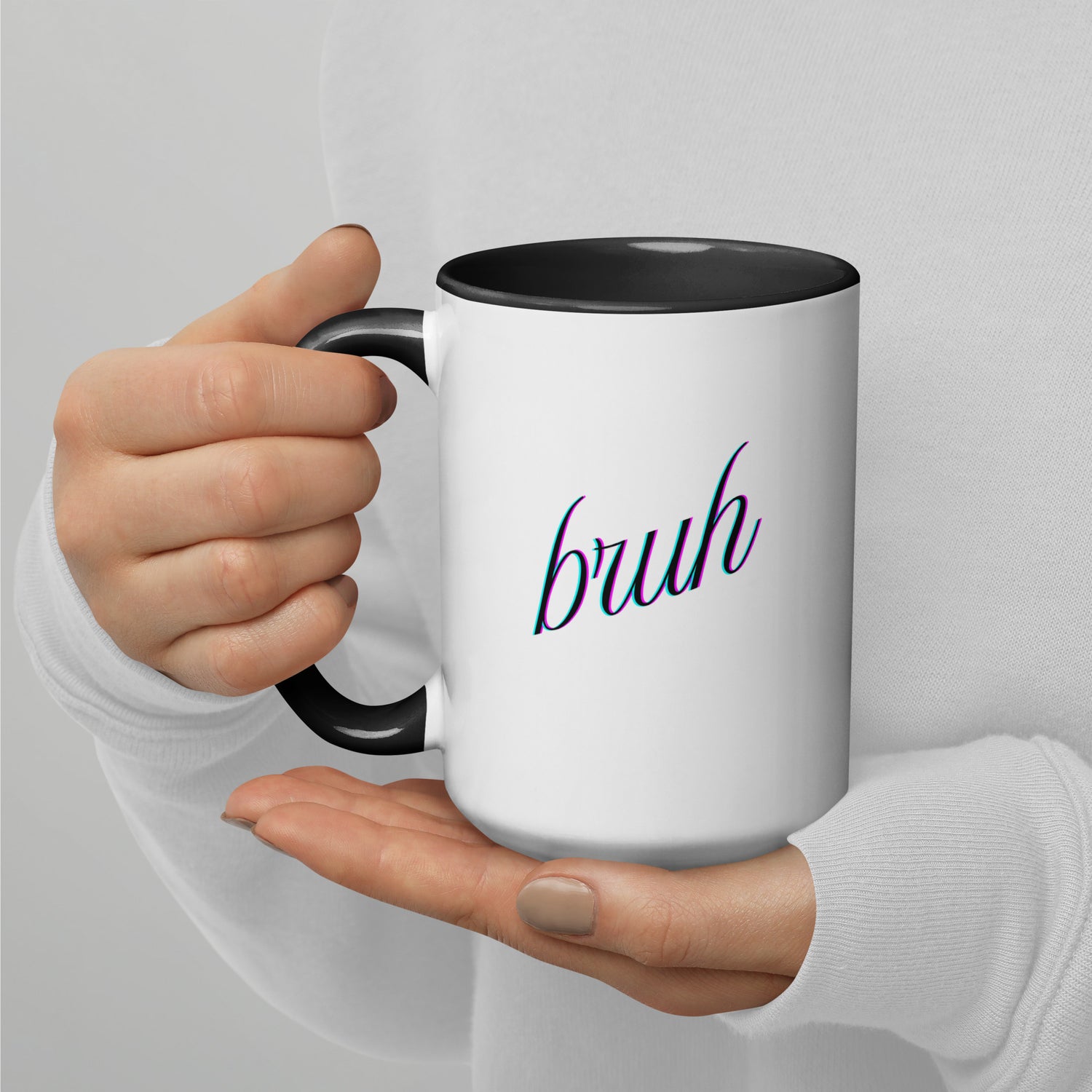 Hand gripping white mug with black rim and handle, purple cursive "bruh" flexin' front and center