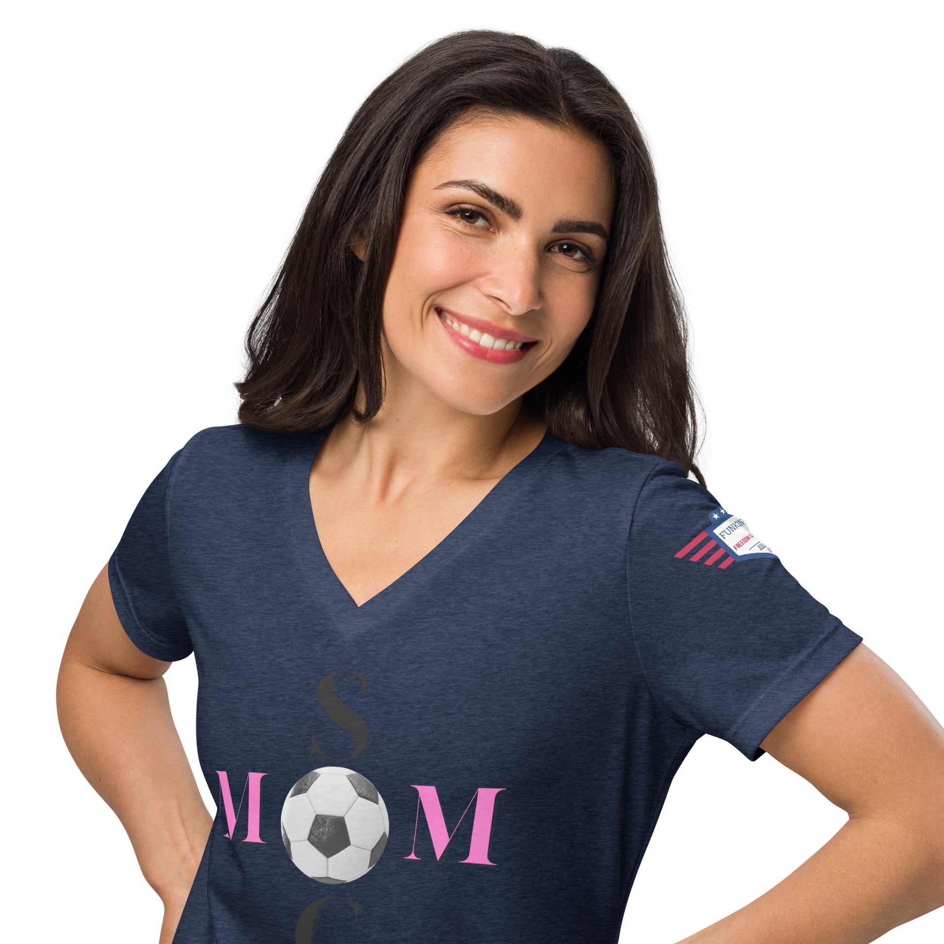 Brunette model rocking navy v-neck Soccer Mom tee, pink "MOM" soccer ball print with black "SOCCER", flag on sleeve, hands on hips
