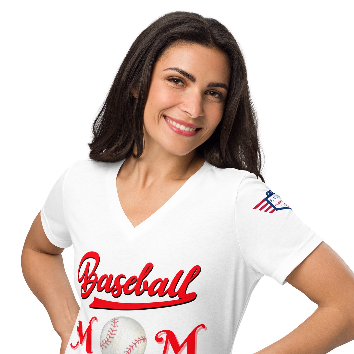 Smiling model in white v-neck Baseball Mom t-shirt, red "Baseball Mom" print, tiny flag patch on shoulder, hands on hips