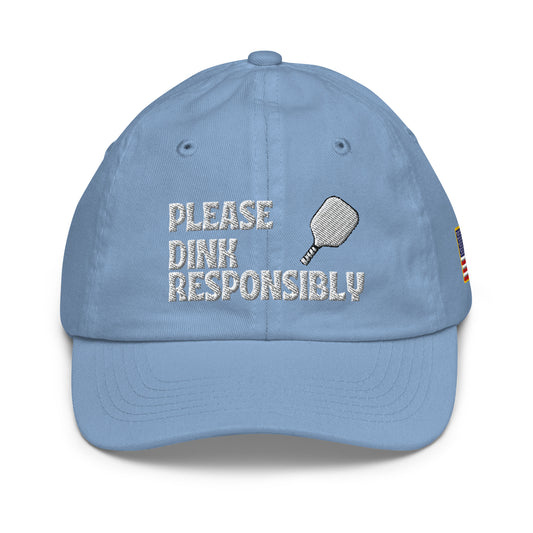 Front view of baby blue youth cap embroidered "Please Dink Responsibly" with pickleball paddle and flag