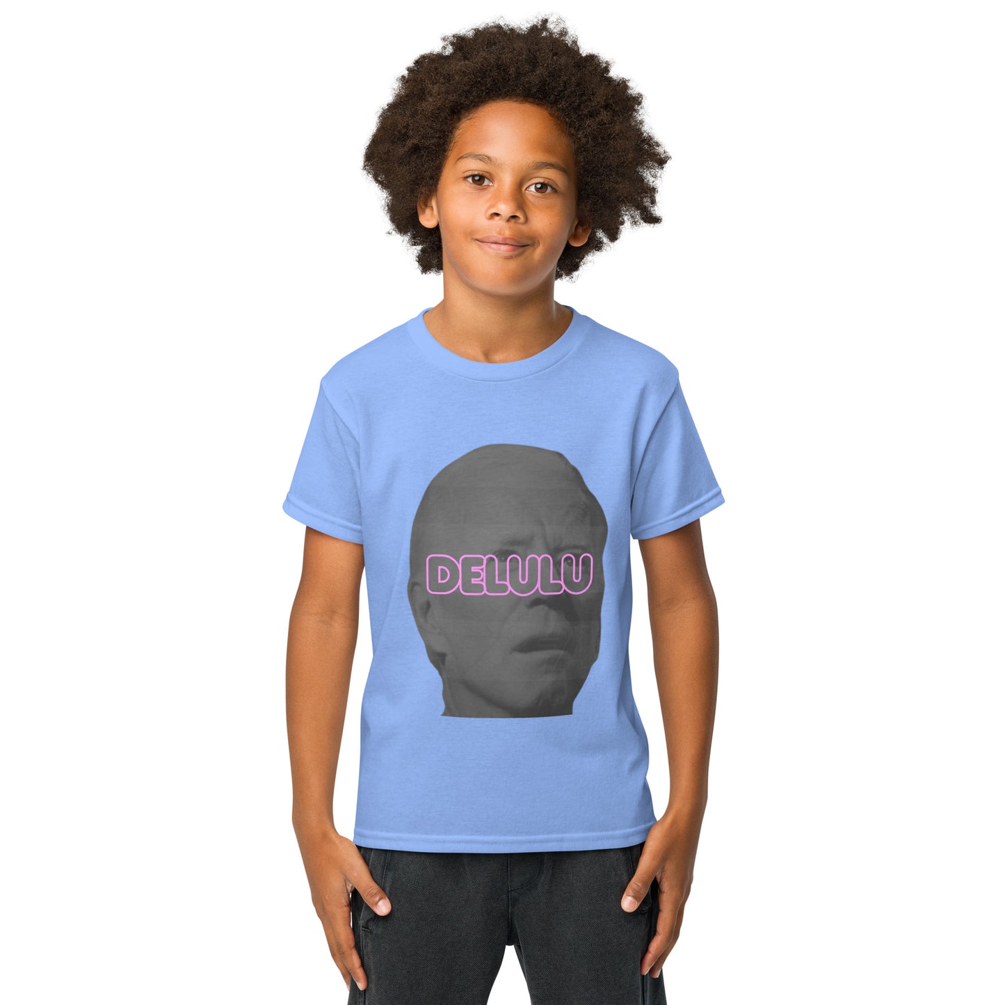 Front view of smiling kid in Carolina blue youth Delulu t-shirt, gray face silhouette with pink "DELU" print