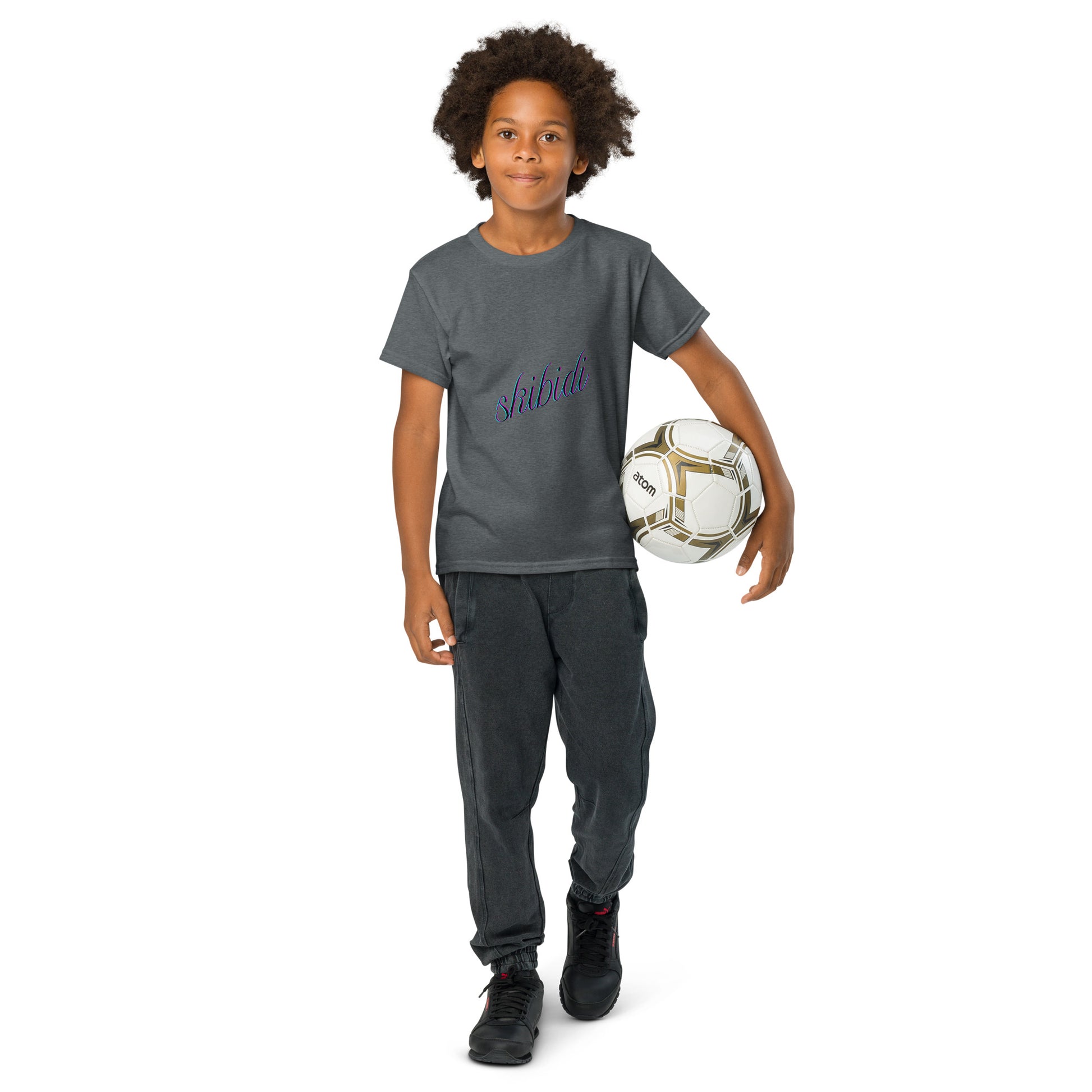 Young model holding soccer ball in dark heather gray "skibidi" youth tee, purple script front