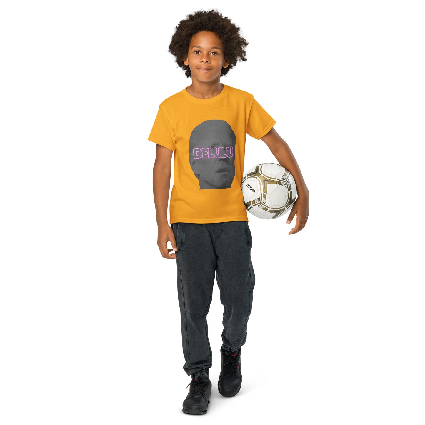 Lifestyle front shot: kid with soccer ball rocking gold youth Delulu t-shirt