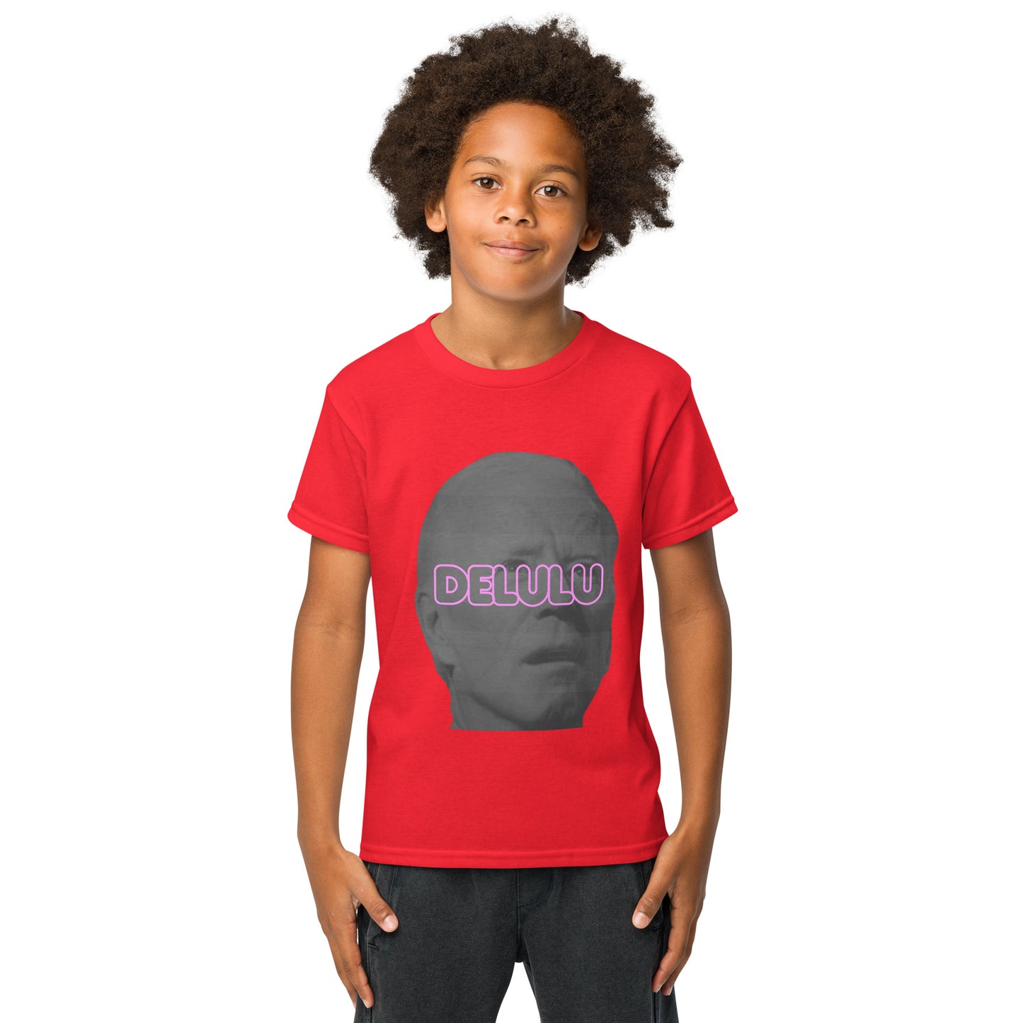 Smiling kid rocks front of red Delulu youth t-shirt, pink "DELULU" glowing over gray face