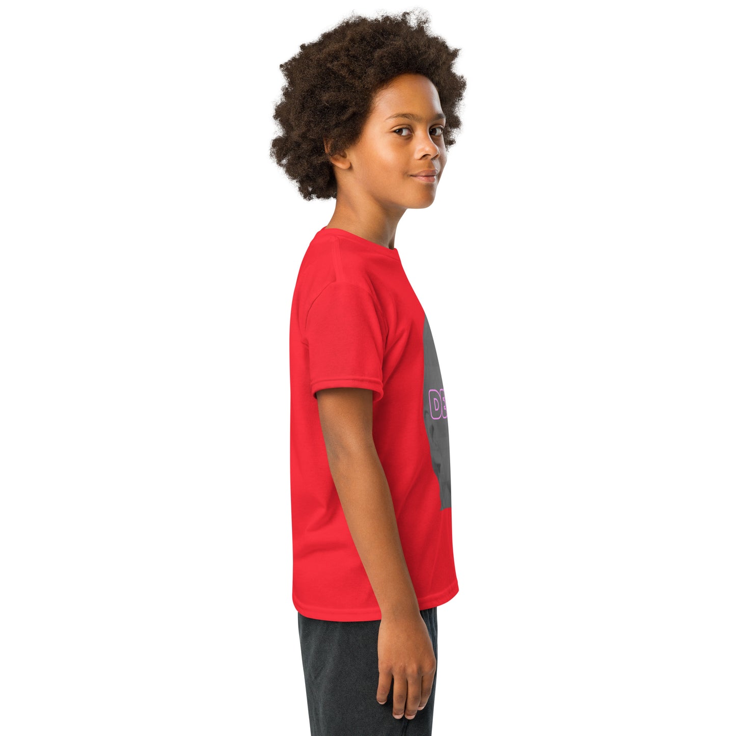 Side angle of boy modeling red Delulu t-shirt with partial pink "DELU" on gray portrait