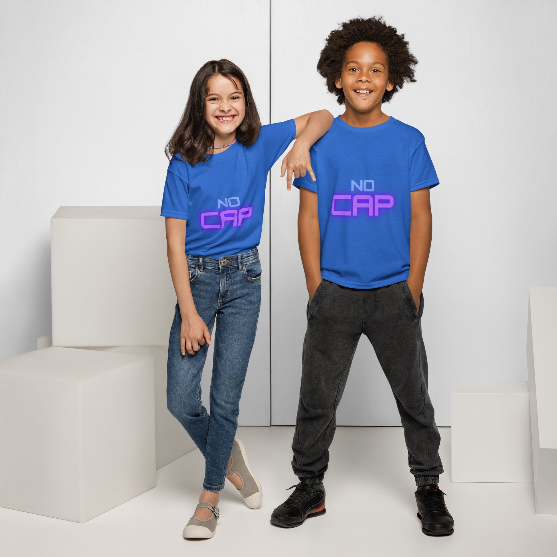 Two kids owning royal blue "No Cap" youth tees, playful front duo shot